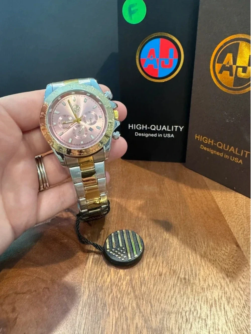 AJ stainless steel watch, pink face, gold & silver toned band